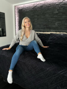 Kuvassa Yasmin Vatanen istuu iloisena TEMPUR-sängyllään.